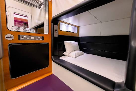 A small cabin with a wall-mounted bed and a panel of switches beside it