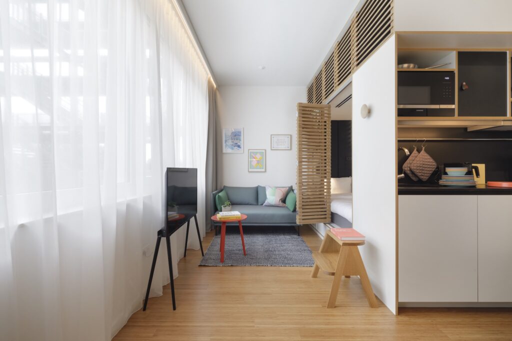 A compact living space with a raised sleeping level above a work desk